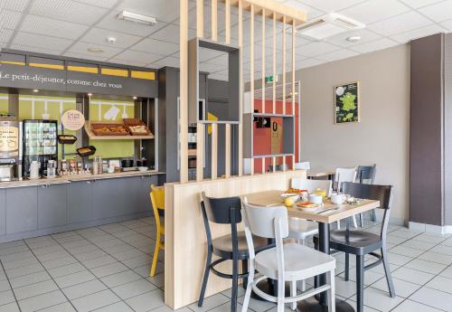 un restaurant de restauration rapide avec une table et des chaises dans l'établissement B&B HOTEL Rouen Saint-Étienne-du-Rouvray, à Saint-Étienne-du-Rouvray