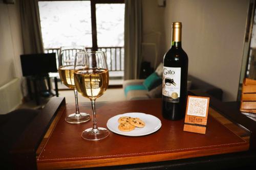a table with two glasses of wine and a plate of cookies at HOM I 1D1B en Valle Nevado Edif Valle Condores II VC2803 in Lo Barnechea