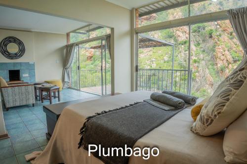 a bedroom with a large bed with a large window at Thabela Thabeng in Parys