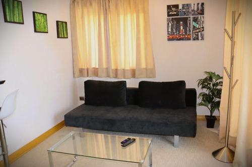 a living room with a couch and a glass table at HOM I En Valle Cóndores II 4PAX con vista la Cordillera CV2402 in Farellones