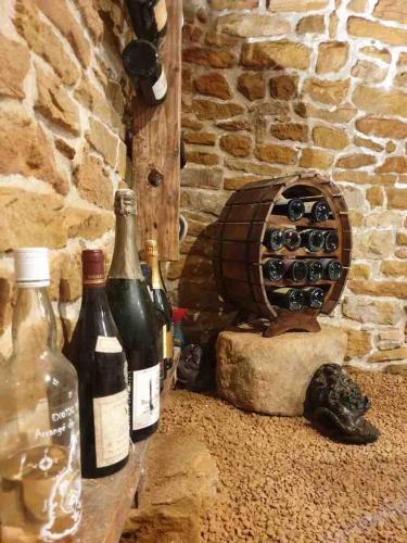 - deux bouteilles de vin à côté d'un four en pierre dans l'établissement La Casa Dorée, à Charnay