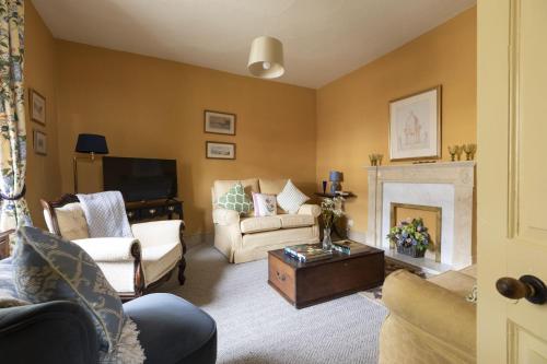 ein Wohnzimmer voller Möbel und einem Kamin in der Unterkunft Palace Garden Cottage in Bishop Auckland