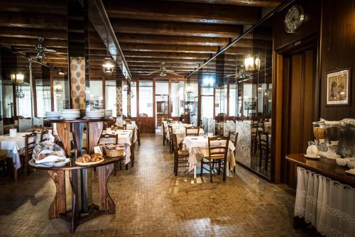 restauracja ze stołami i krzesłami w pokoju w obiekcie Hotel Johnson w mieście Peschiera del Garda