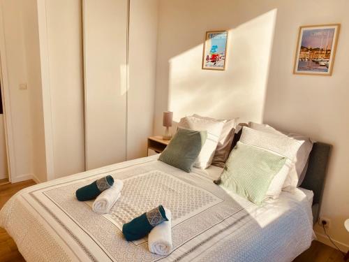 une chambre avec un lit avec deux pantoufles dessus dans l'établissement Elégant T3 Cannes centre, 10 mn à pieds Palais, Croisette, à Cannes