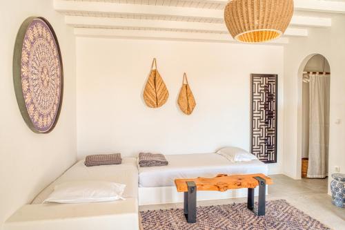 two beds in a room with a table on a rug at Santa Maria Hotel in Elia Beach
