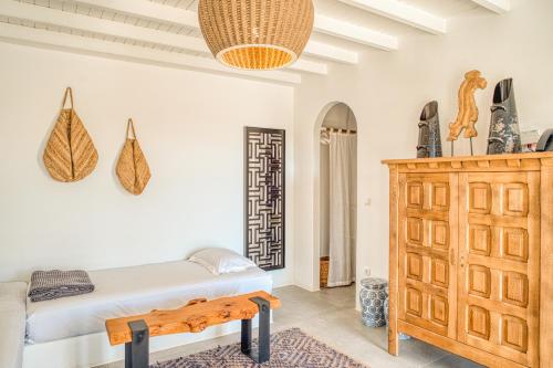 a bedroom with a bed and a wooden cabinet at Santa Maria Hotel in Elia Beach