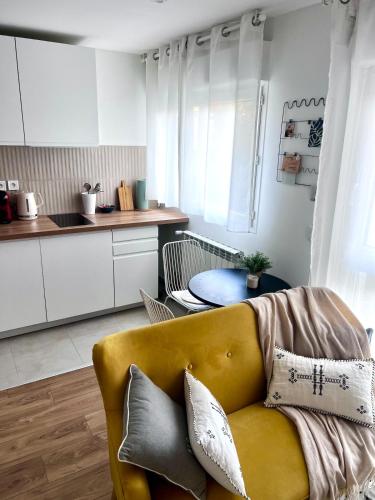 un salon avec un canapé jaune et une table dans l'établissement Beautiful apartment near Stade de France and Paris, à Saint-Denis