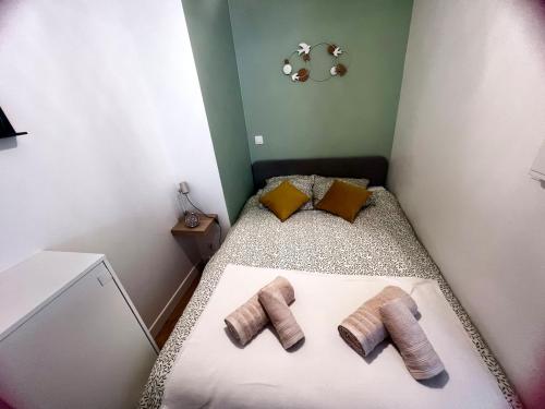 a small room with a bed with two pairs of socks at Beautiful apartment near Stade de France and Paris in Saint-Denis