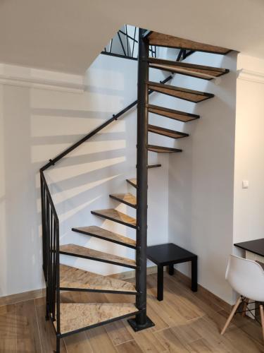 a metal spiral staircase in a white room with a bench at Willa Park in Ostrowiec Świętokrzyski