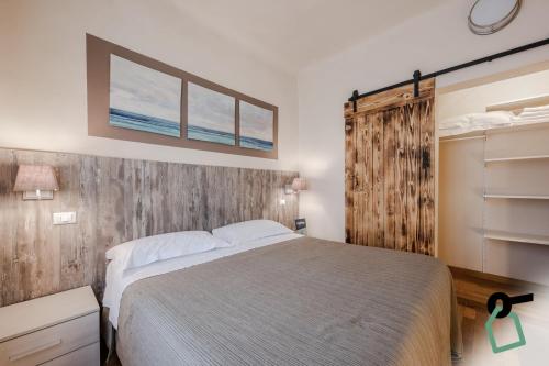 a bedroom with a bed and a wooden wall at HOTIDAY Apartment Collection - Lerici Terrediliguria in Lerici