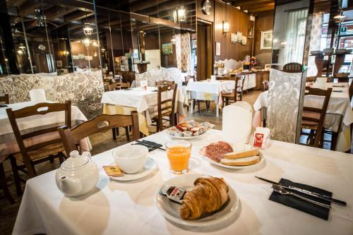 een tafel met een ontbijt van croissants en jus d'orange bij Hotel Johnson in Peschiera del Garda