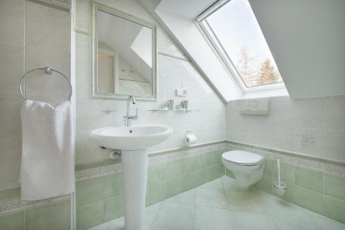 a bathroom with a sink and a toilet with a window at A. V. Pension Praha in Prague
