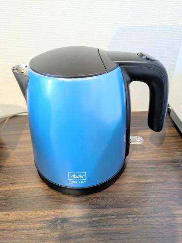 a blue toaster sitting on top of a wooden table at 宮泊syukugo宇都宮東口徒歩5分 in Utsunomiya