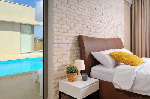 a bedroom with a bed and a brick wall at Malki House- a whole complex just for you in Lappidot