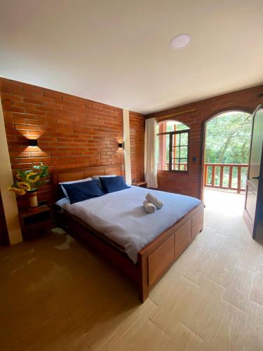 a bedroom with a bed with a teddy bear on it at The Lookout Hideaway in Baños