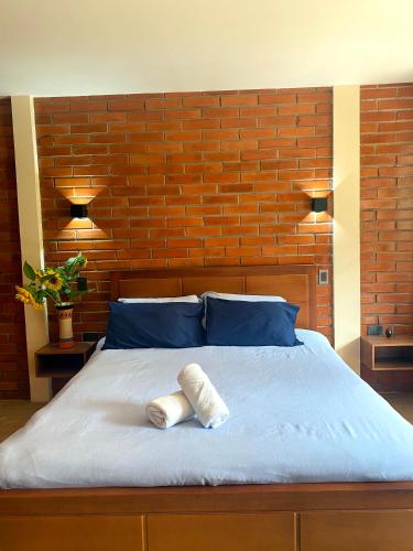 a bedroom with a bed with a brick wall at The Lookout Hideaway in Baños