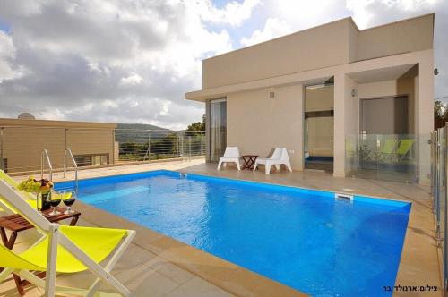 a villa with a swimming pool in front of a house at Malki House- a whole complex just for you in Lappidot