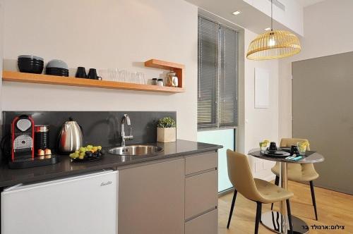 a kitchen with a sink and a table with chairs at Malki House- a whole complex just for you in Lappidot