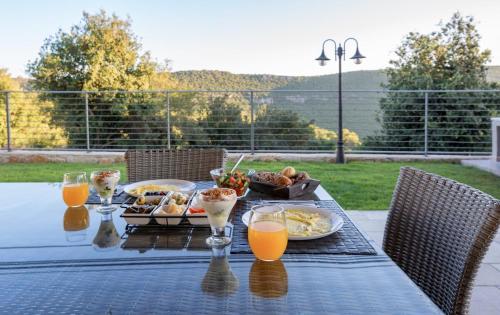 a table with breakfast foods and orange juice on it at Malki House- a whole complex just for you in Lappidot