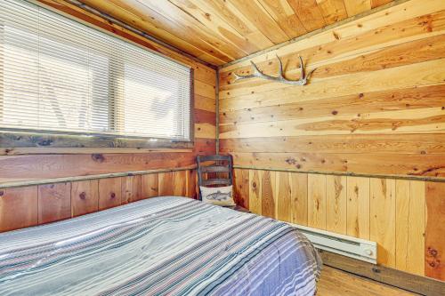 a bedroom with a bed in a wooden cabin at Riverside Retreat in Bridgeport with Game Room! in Bridgeport