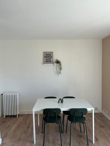 - une table à manger blanche avec 4 chaises vertes dans l'établissement F4 lumineux proche Gare et centre ville, à Orléans