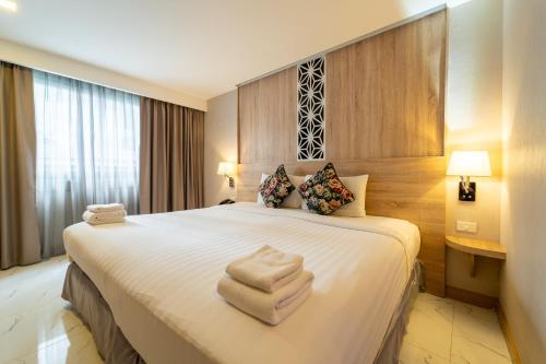 a hotel room with a bed with towels on it at Rodina Beach Hotel in Jomtien Beach