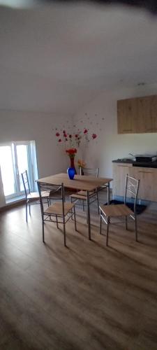 a table and chairs in a room with a vase on it at Gîte du Manoir in Seurre