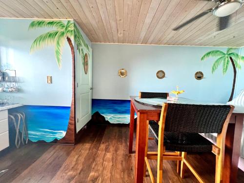 a dining room with a palm tree mural on the wall at Kailua Kona Overlook Suites in Kailua-Kona