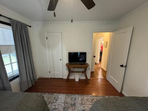 a bedroom with a television and a table in a room at Tulsa Home Sweet Home - King Bed Near Expo, TU, Dtwn in Tulsa