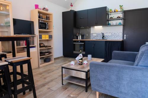 un salon avec un canapé bleu et une table dans l'établissement Gîte des dolmens 3 etoiles, à Saint-Quay-Portrieux