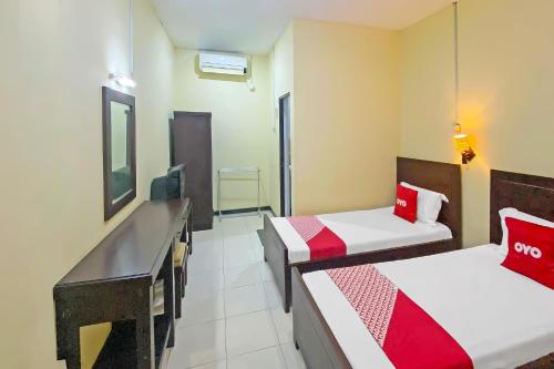 古邦Hotel O Gajah Mada Indah的一间有两张床和一台电视的酒店房间