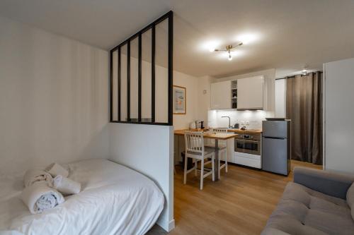 Cet appartement comprend une chambre avec un lit et une cuisine avec un canapé. dans l'établissement Balcon d'Albigny - proche lac & vue montagne, à Annecy