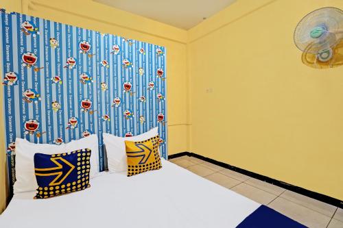 a bedroom with a bed with a blue and yellow wall at OYO Life 91947 Kost Barokah Syariah in Mojokerto