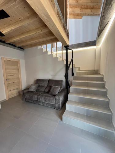 a living room with a couch and a staircase at La LIPA SUITES con piscina privada in Almáchar