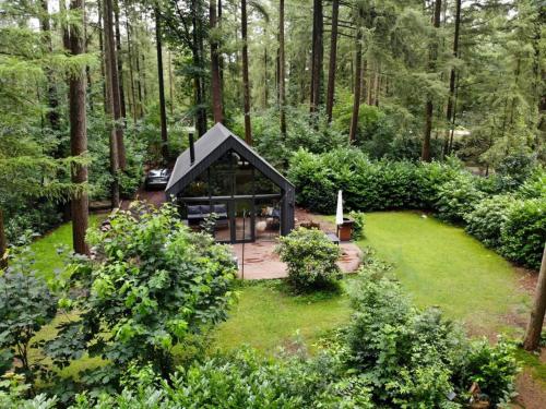 a small cabin in the middle of a garden at Fantastisch luxe boshuis I Onthaasten in de natuur in Emst