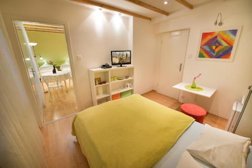 a bedroom with a yellow bed and a table at A. V. Pension Praha in Prague