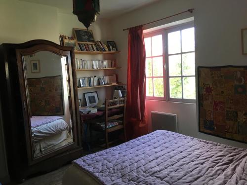 - une chambre avec un miroir, un lit et une fenêtre dans l'établissement Très jolie maison d'artiste,jardin,proche mer, à La Rochelle
