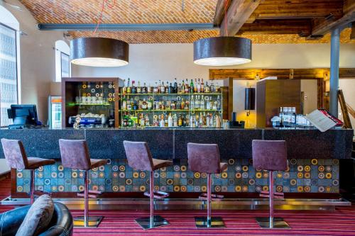 a bar with purple chairs in a room at Młyn Jacka Hotel & Spa in Wadowice