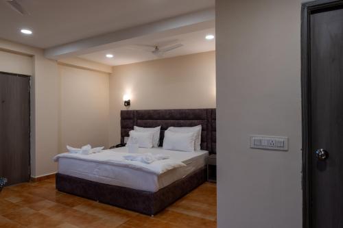 a bedroom with a large bed with white sheets and pillows at Evoke Express Candolim in Candolim