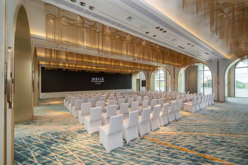 an empty room with white chairs and a stage at Meliá Pattaya Hotel in Pattaya Central
