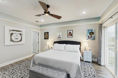 Un dormitorio con una cama y un ventilador de techo. en Gruene Luxury on the Guadalupe, en New Braunfels