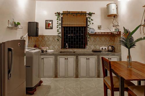 ヴァガトールにあるGOAROUND- Grand Chivar 1BHK Villa by Goaround Homes at Vagatorのキッチン(冷蔵庫、テーブル付)