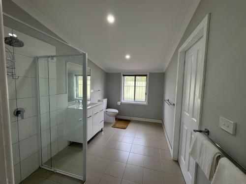 a bathroom with a glass shower and a toilet at Hay Caravan Park in Hay