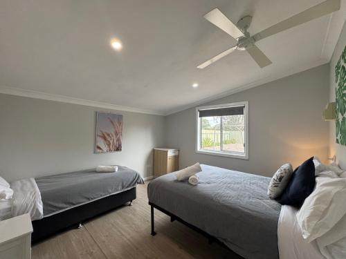 a bedroom with two beds and a ceiling fan at Hay Caravan Park in Hay