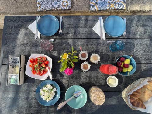 a wooden table with bowls and plates of food at Villa Dolce Valle in Ragusa