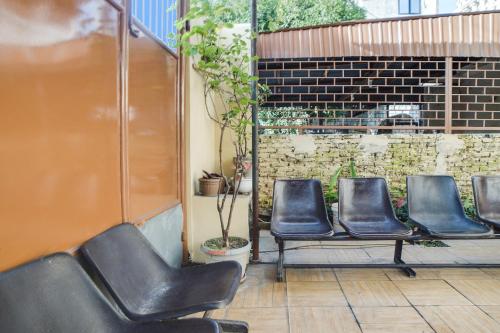a row of leather chairs sitting on a patio at Hotel O Kost Ketapang Syariah in Medan