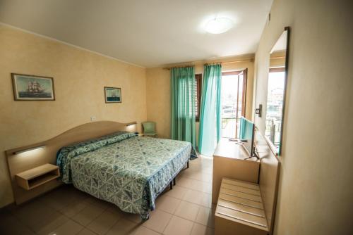 sypialnia z łóżkiem i oknem w obiekcie Hotel Johnson w mieście Peschiera del Garda