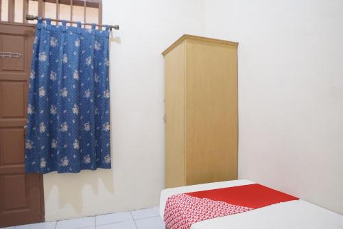 a room with a bed and a curtain at Hotel O Kost Ketapang Syariah in Medan