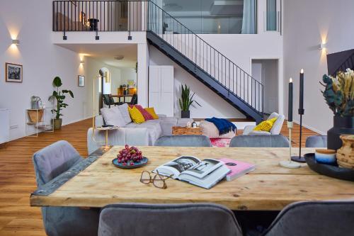 a large wooden table in a living room with a couch at Wstay Industrie Charme DELUXE in Steinfurt