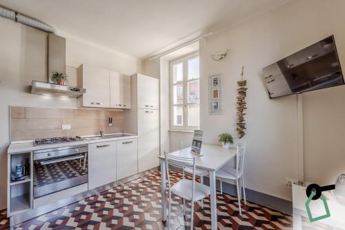 a kitchen with white cabinets and a table and chairs at HOTIDAY Apartment Collection - Lerici Terrediliguria in Lerici